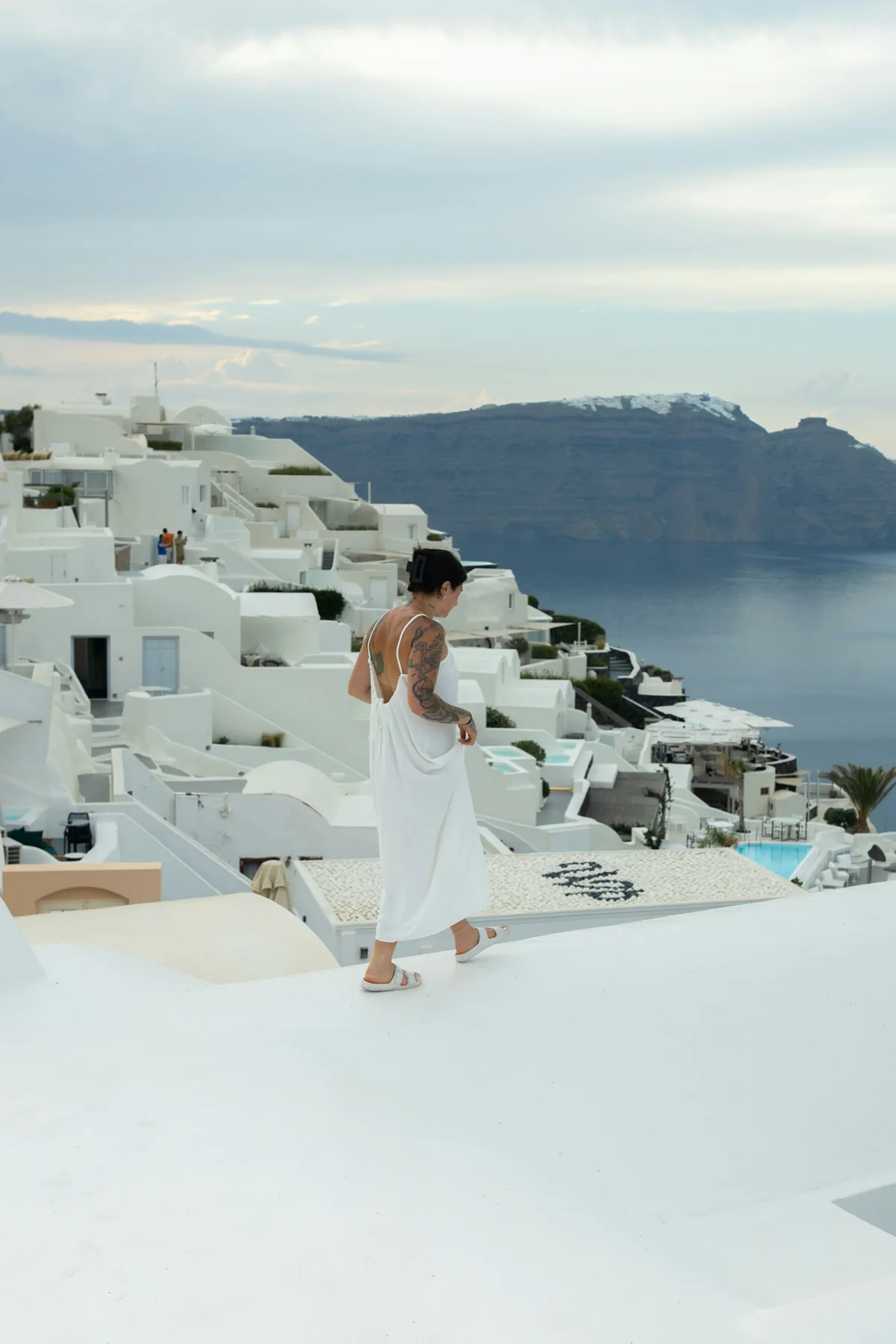 Mulher viajando em Santorini, com vista para o mar